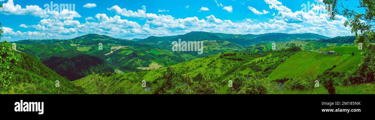 Riesiges horizontales Panoramablick auf grüne italienische Hügel, sonniger Hintergrund Stockfoto