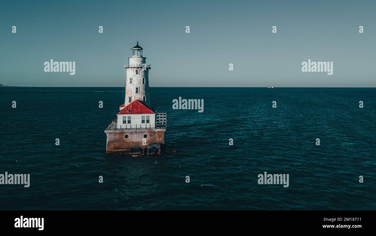 Der Chicago Harbor Lighthouse liegt am Chicago River und ist vor einem blauen Hintergrund zu sehen Stockfoto