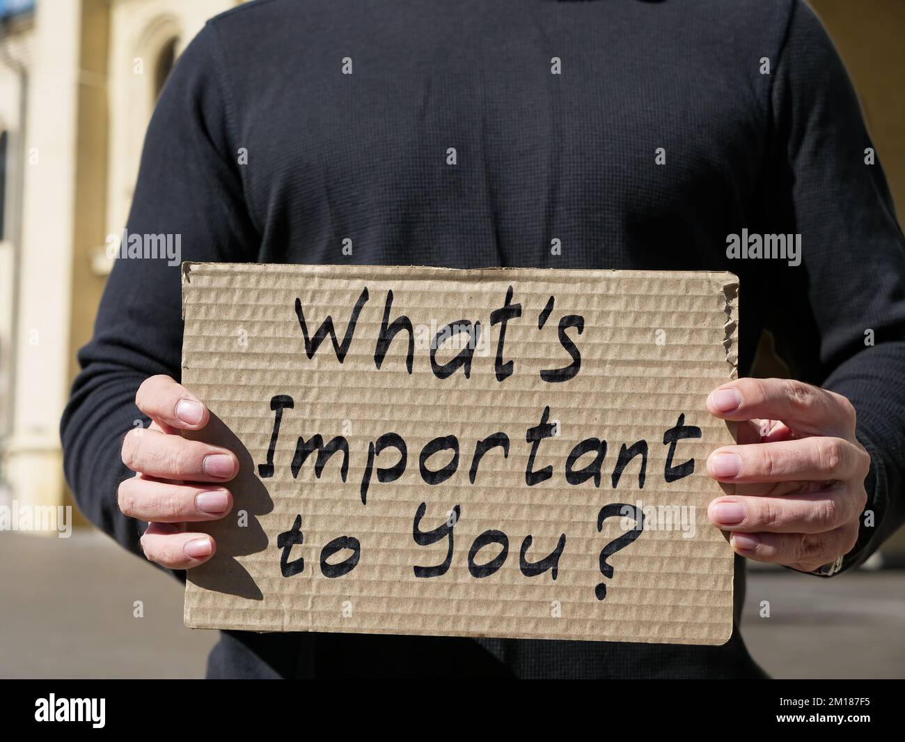 Ein Mann hält ein Poster mit der Inschrift Was ist dir wichtig? Stockfoto