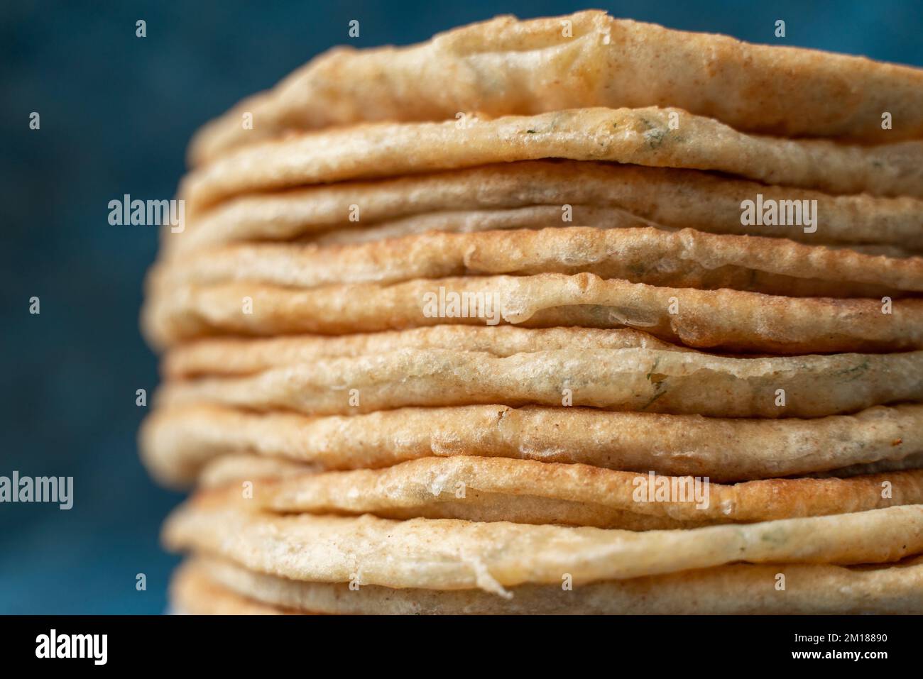 Fladenbrot Lavash, Chapati, Naan, ein Haufen Tortilla auf blauem Hintergrund hausgemachtes Fladenbrot gestapelt. Stockfoto