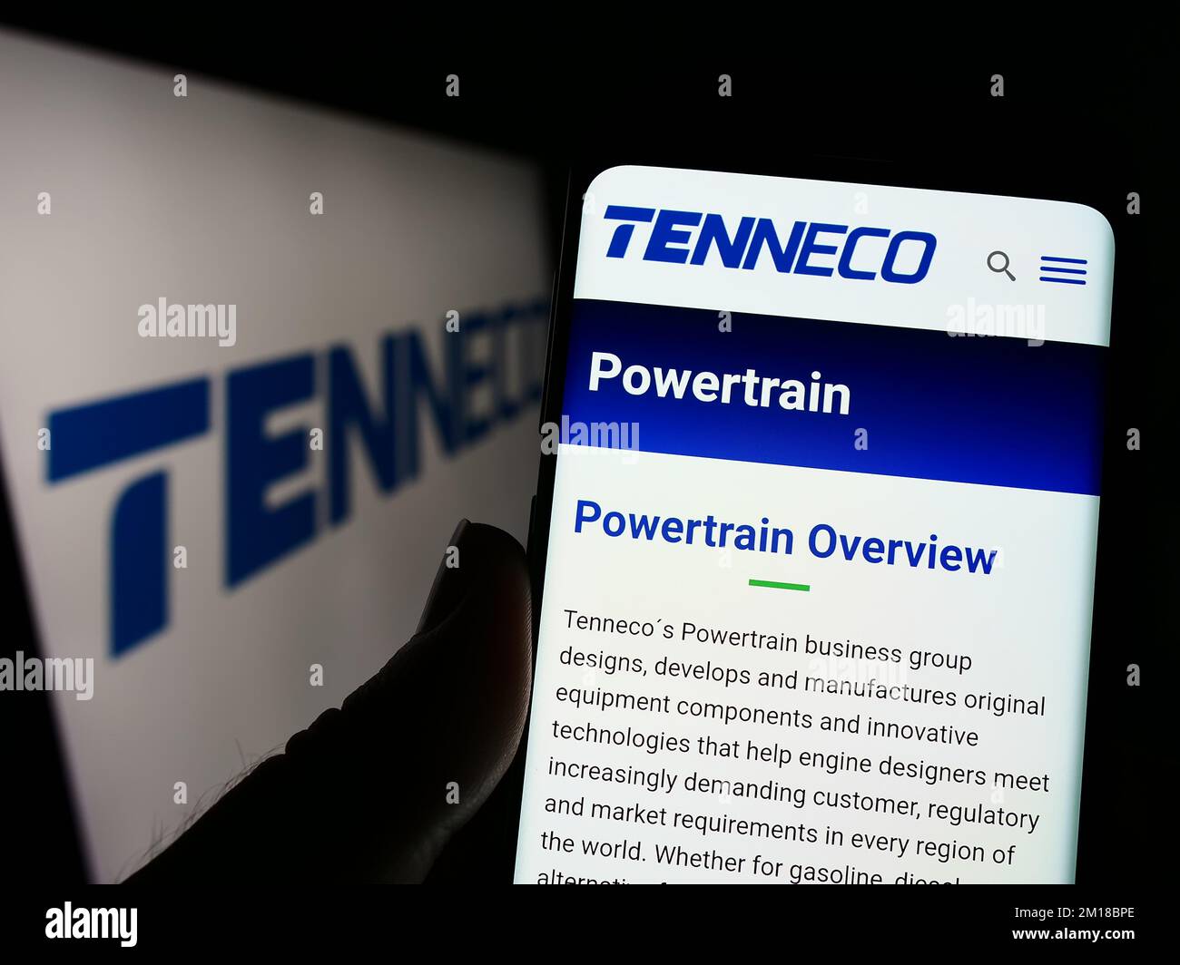 Person, die ein Mobiltelefon mit einer Webseite des amerikanischen Automobilunternehmens Tenneco Inc. Auf dem Bildschirm vor dem Logo hält. Konzentrieren Sie sich auf die Mitte des Telefondisplays. Stockfoto