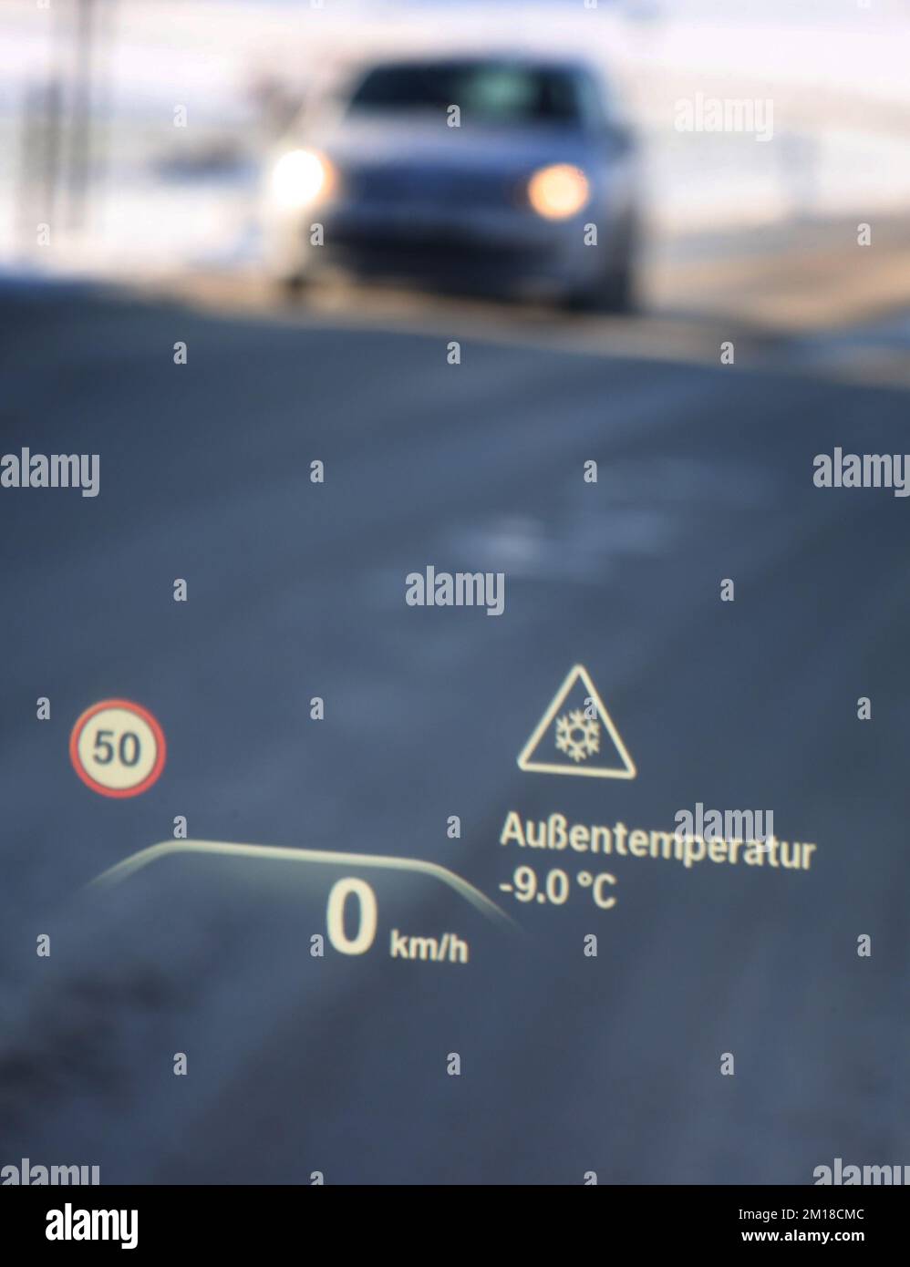 Ruderatshofen, Deutschland. 11.. Dezember 2022. Ein Head-up-Display auf der Windschutzscheibe eines Autos weist auf die Gefahr vereister Straßen und einer Temperatur von minus neun Grad Celsius hin. Kredit: Karl-Josef Hildenbrand/dpa/Alamy Live News Stockfoto