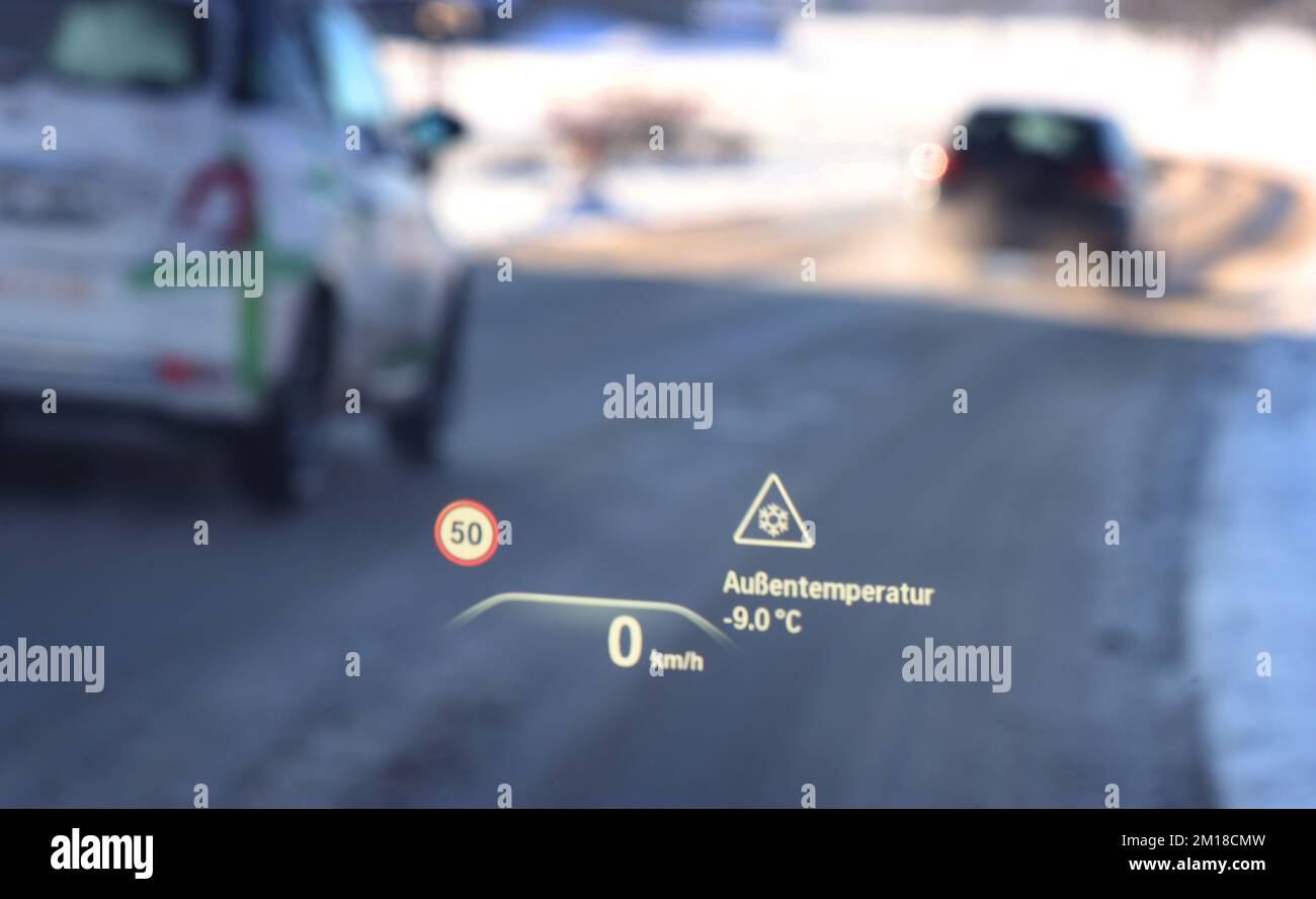 Ruderatshofen, Deutschland. 11.. Dezember 2022. Ein Head-up-Display auf der Windschutzscheibe eines Autos weist auf die Gefahr vereister Straßen und einer Temperatur von minus neun Grad Celsius hin. Kredit: Karl-Josef Hildenbrand/dpa/Alamy Live News Stockfoto