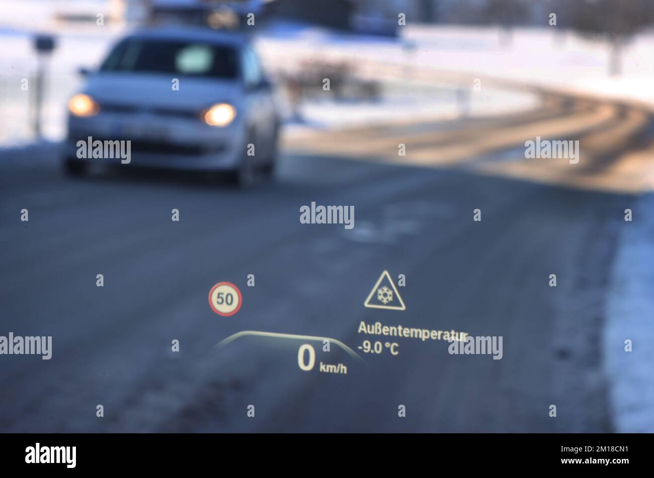 Ruderatshofen, Deutschland. 11.. Dezember 2022. Ein Head-up-Display auf der Windschutzscheibe eines Autos weist auf die Gefahr vereister Straßen und einer Temperatur von minus neun Grad Celsius hin. Kredit: Karl-Josef Hildenbrand/dpa/Alamy Live News Stockfoto