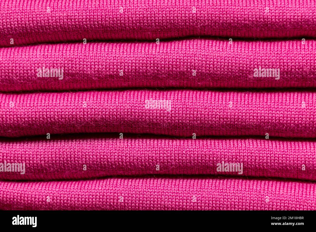 HINTERGRUNDSTRUKTUR – gefaltete Stücke aus blauem Strickstoff Stockfoto
