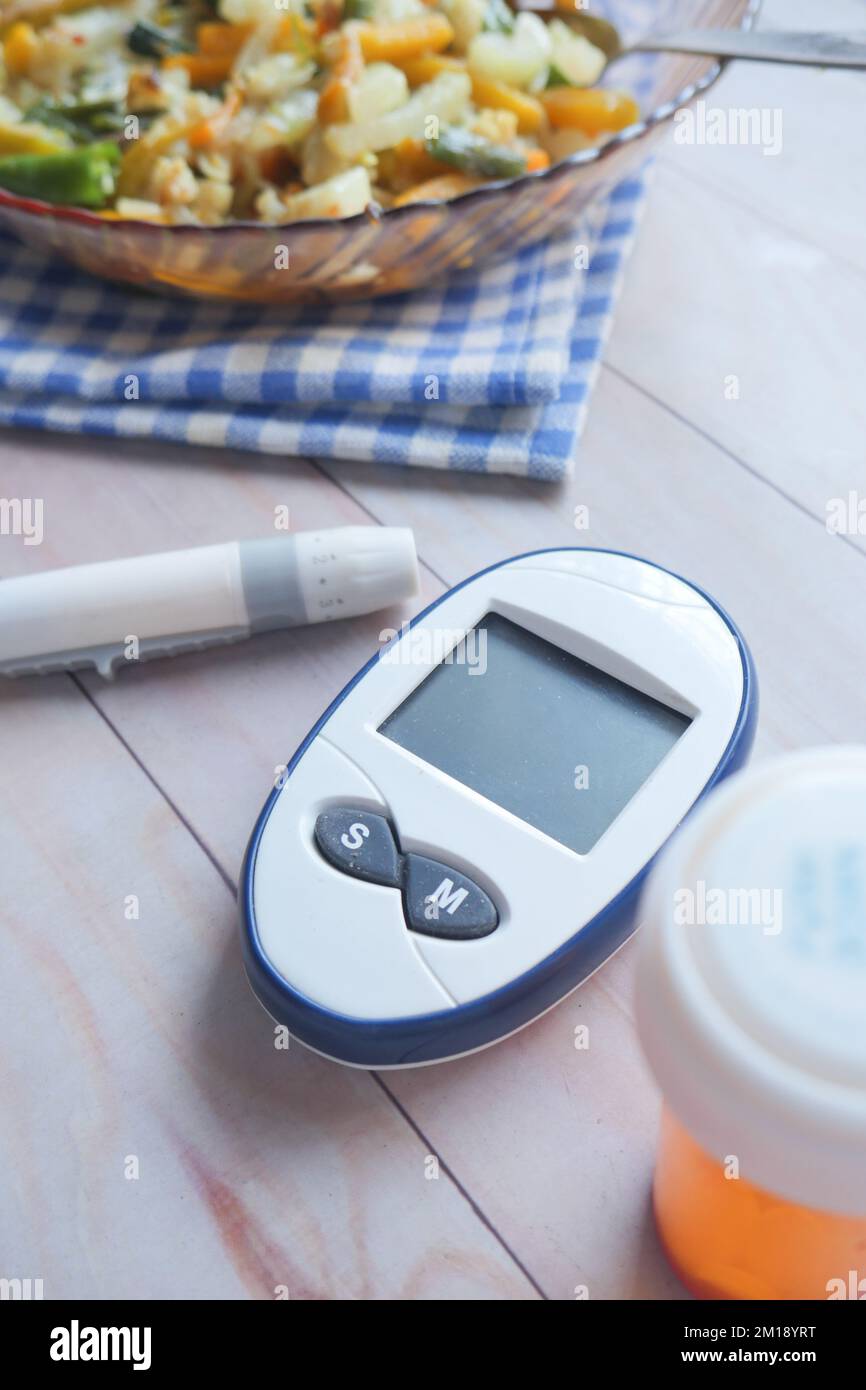 Vertikale Aufnahme von Diabetikermessgeräten und gesundem Essen auf dem Tisch Stockfoto