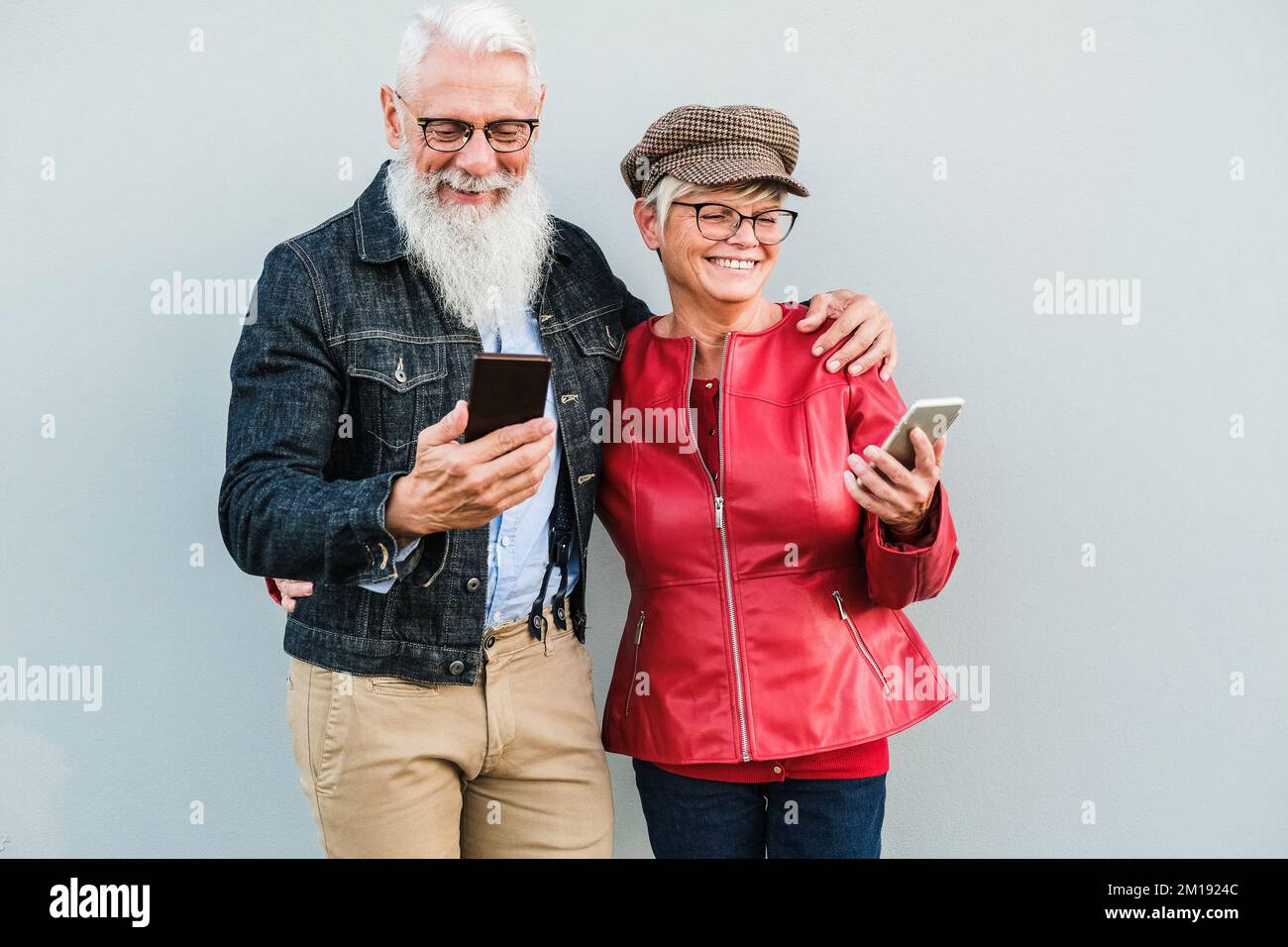 Seniorenpaar, das Spaß mit Mobiltelefonen im Freien hat – Fokus auf Gesichter Stockfoto