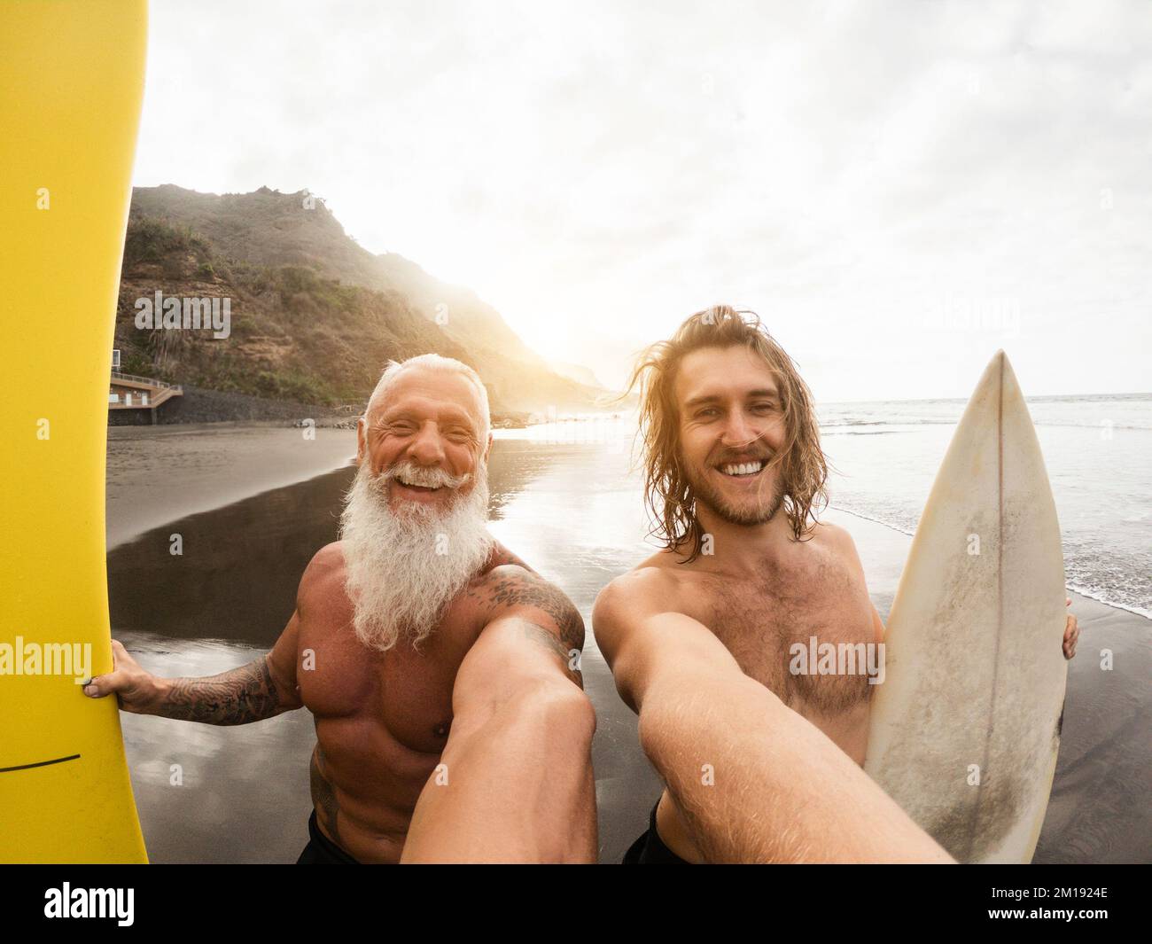 Vater und Sohn haben Spaß beim Selfie am Strand nach dem Surfen - weicher Fokus auf Männergesicht Stockfoto