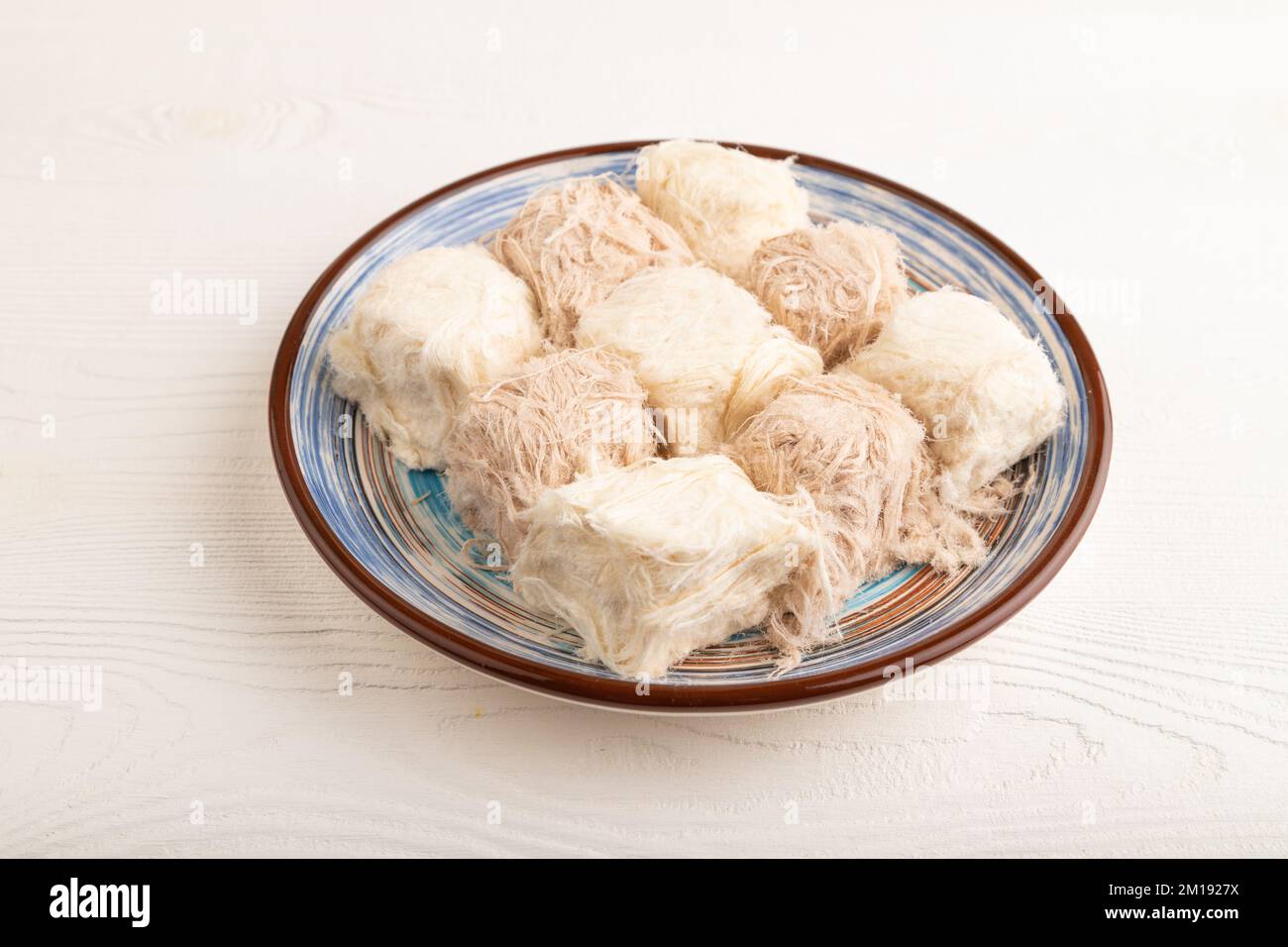Traditionelle arabische Süßigkeiten Pishmanie auf weißem Holzhintergrund. Seitenansicht, Nahaufnahme. Stockfoto
