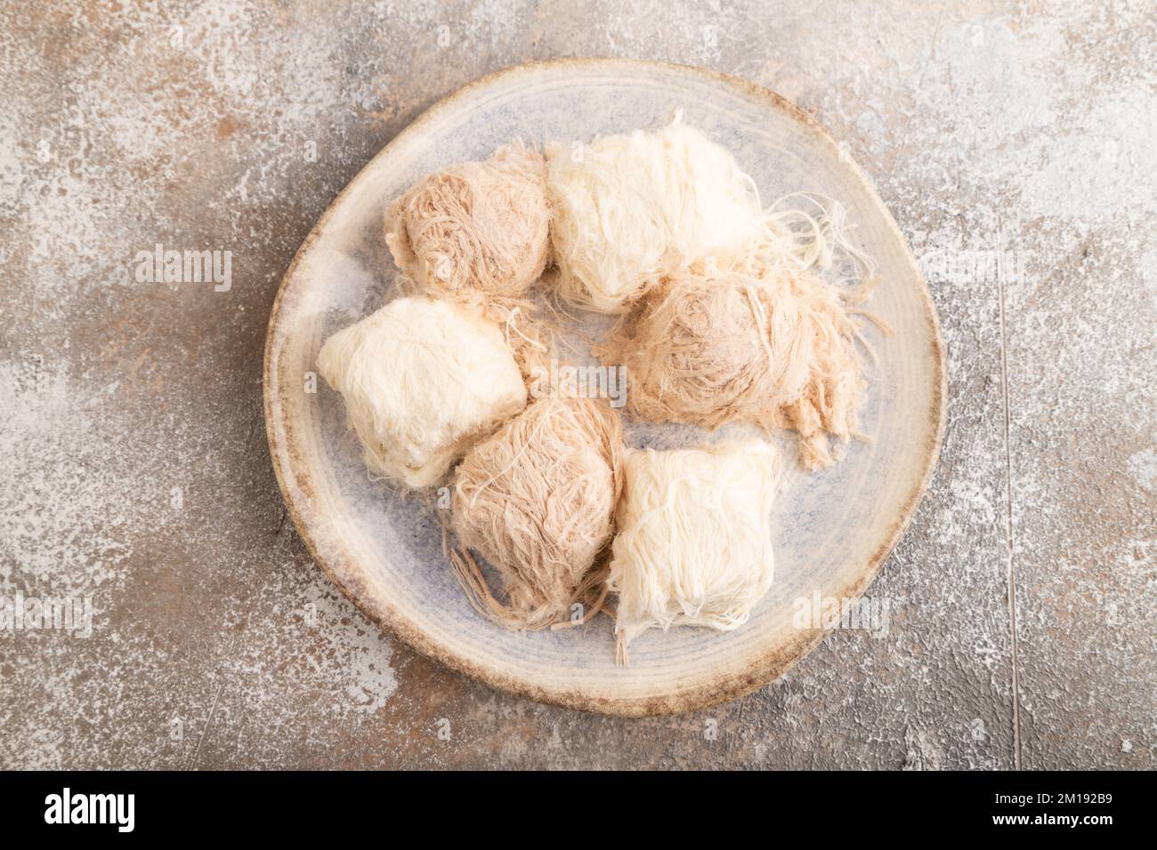 Traditionelle arabische Süßigkeiten Pishmanie auf braunem Betonhintergrund. Draufsicht, flach liegend, Nahaufnahme. Stockfoto