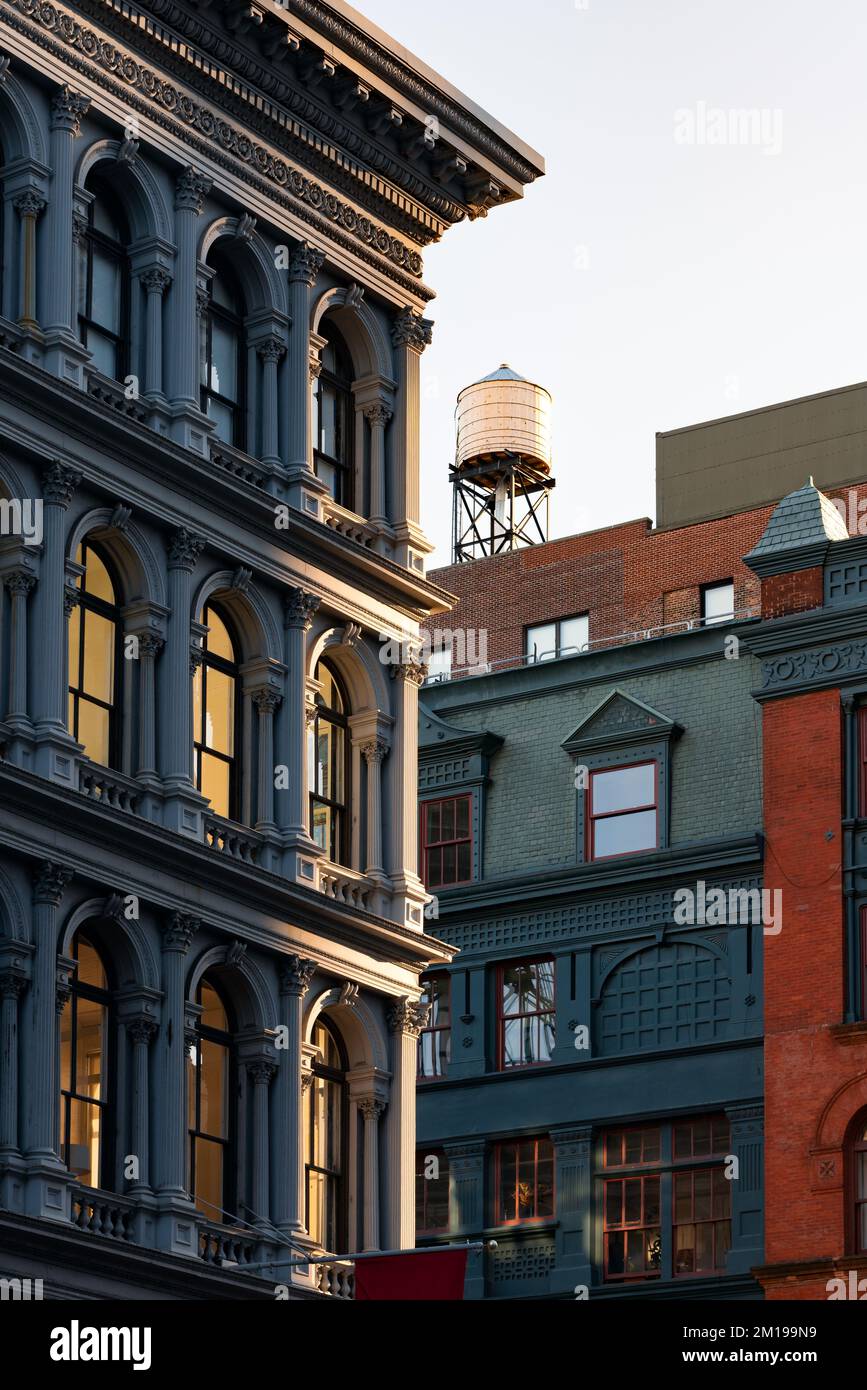 Gusseiserne Fassade des Soho Loft-Gebäudes und Wasserturm auf dem Dach entlang des Broadway. Soho Cast Iron Building Historic District, Manhattan, New York City Stockfoto