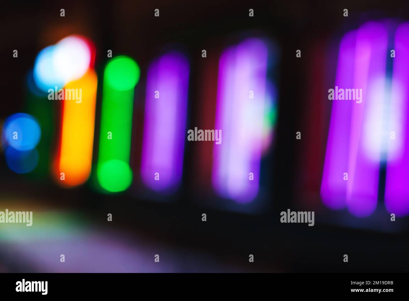 Verschwommene Neonlichter der Straßenwerbung, abstraktes, unfokussiertes Hintergrundbild Stockfoto