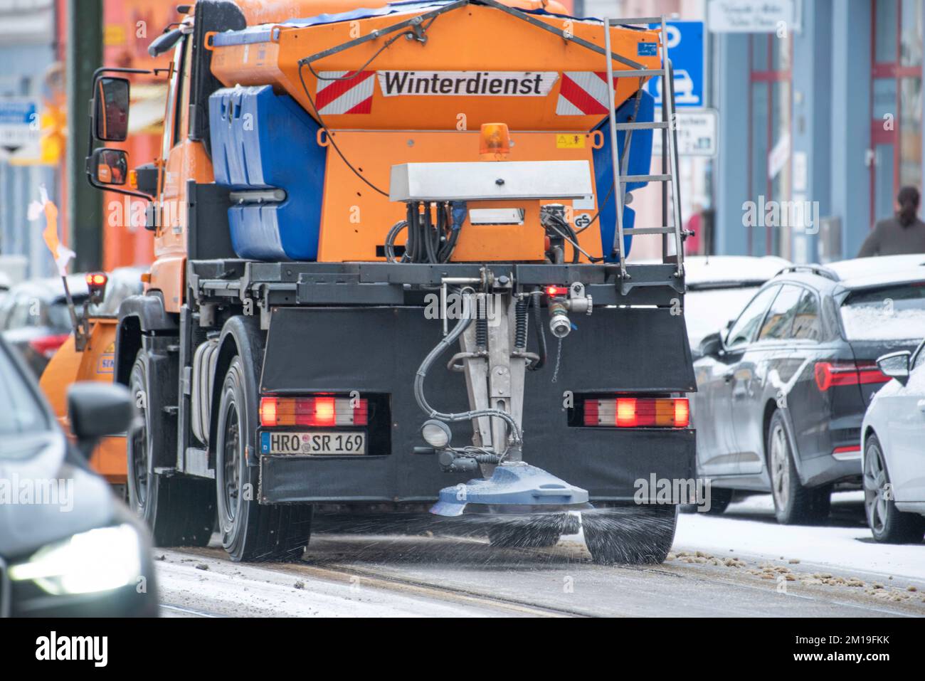Rostock, Deutschland. 11.. Dezember 2022. Ein Straßenfahrzeug der Winterpolizei, das auf einer Hauptstraße im Stadtzentrum Müll verbreitet. Aufgrund von Schneefall und vereisten Straßen gibt es in Norddeutschland Verkehrsbehinderungen. Kredit: Frank Hormann/dpa/Alamy Live News Stockfoto