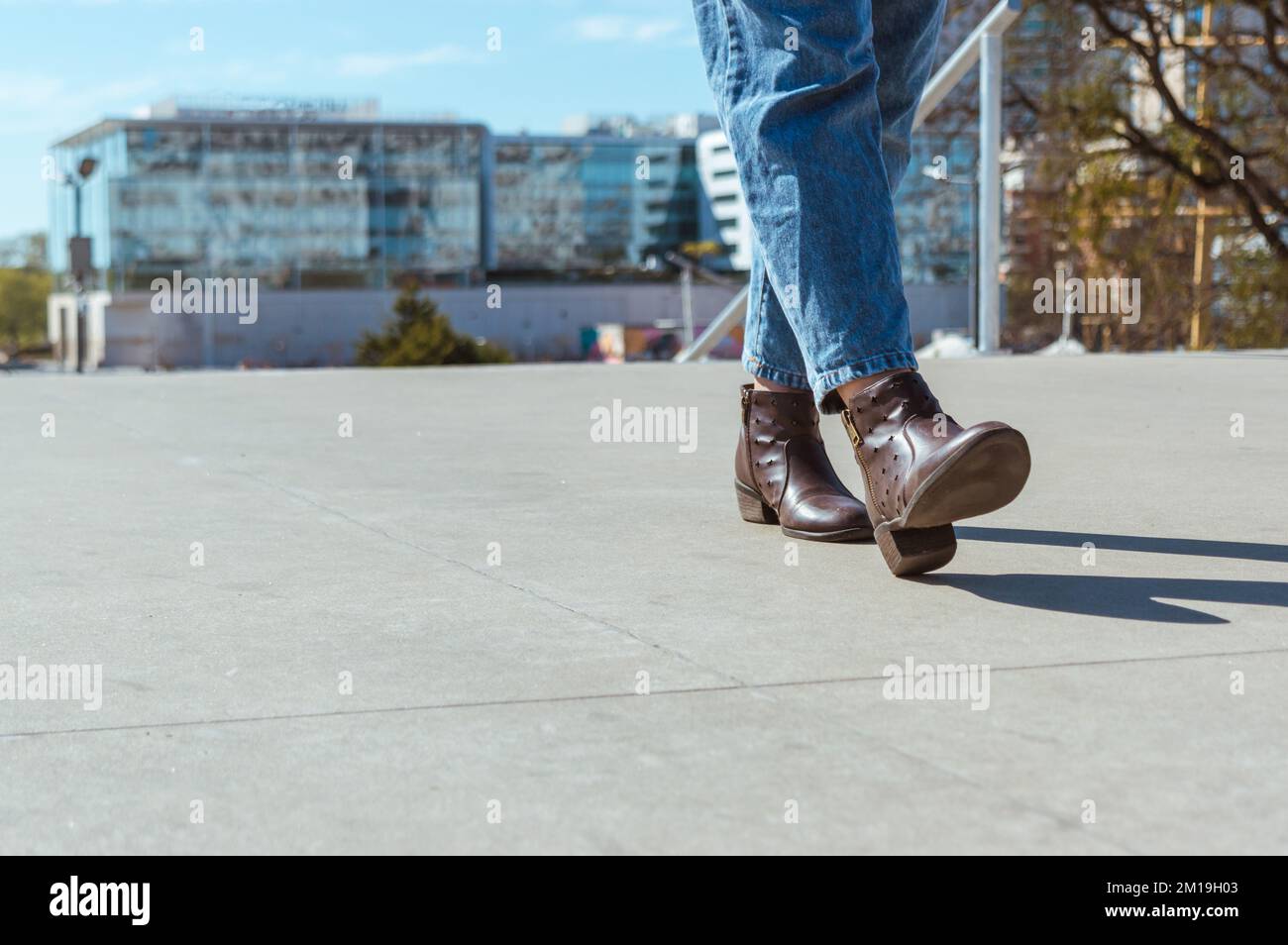 Nahaufnahme von Lederschuhen und -Beinen einer Frau, die die Straße entlang läuft, in blauen jeans-Shorts, die zur Arbeit gehen, Kopierraum. Stockfoto