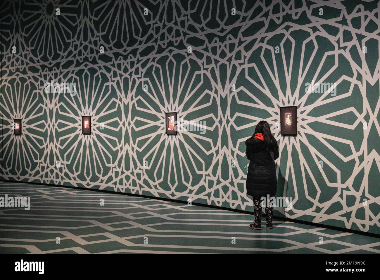 London, Großbritannien. 11.. Dezember 2022. Besucher sehen sich die ausgestellten Werke an. Der Kurvenraum im Barbican wurde in eine beeindruckende Galerie mit handbemalten Böden und Decken in islamischen Mustern für die Ausstellung „Rebel Rebel“ in Soheila Sokhanvari umgewandelt. Der iranische Künstler stellt Kulturfiguren aus dem Iran in farbenfrohen Miniaturporträts dar und zeigt den Widerspruch zwischen dem Leben iranischer Frauen zwischen der Revolution von 1920er und 1979. Die Ausstellung ist kostenlos und läuft bis zum 26. Februar 2023. Kredit: Imageplotter/Alamy Live News Stockfoto