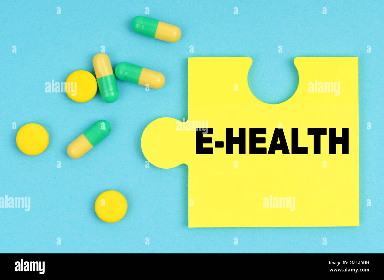 Medizin und Gesundheitskonzept. Auf blauem Hintergrund gibt es Pillen und ein Puzzle mit der Inschrift - E-HEALTH Stockfoto