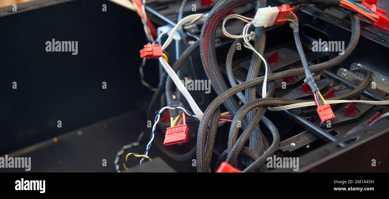 Desktop-Computer, schwarzes leeres Gehäuse und verschiedene Kabel, die versucht werden, in einer häuslichen Umgebung montiert zu werden Stockfoto