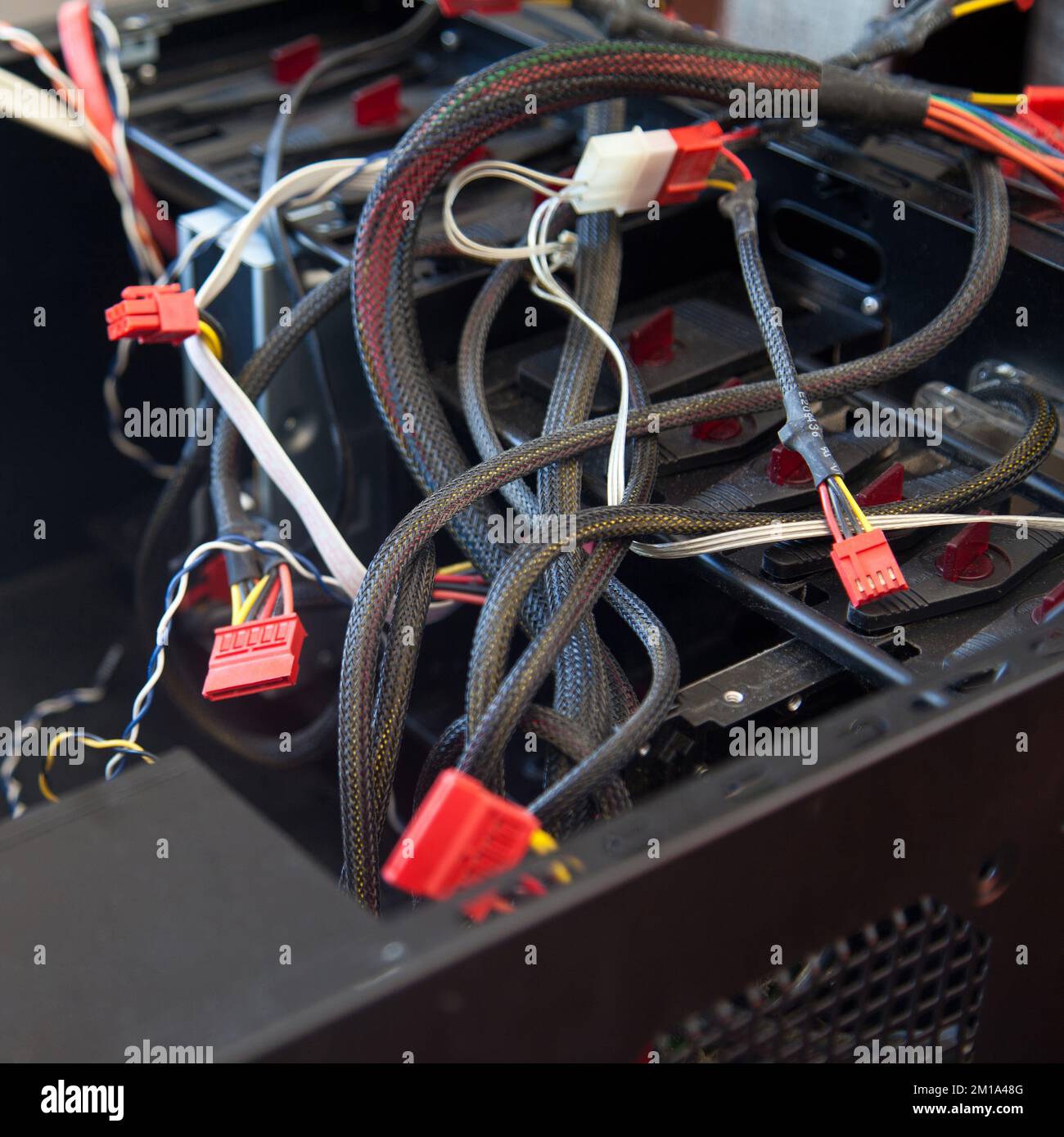 Desktop-Computer, schwarzes leeres Gehäuse und verschiedene Kabel, die versucht werden, in einer häuslichen Umgebung montiert zu werden Stockfoto