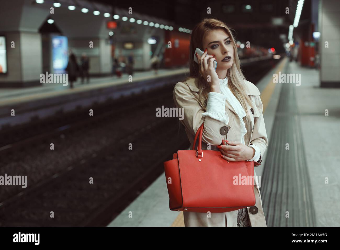 Frau mit Handy im Bahnhof Stockfoto