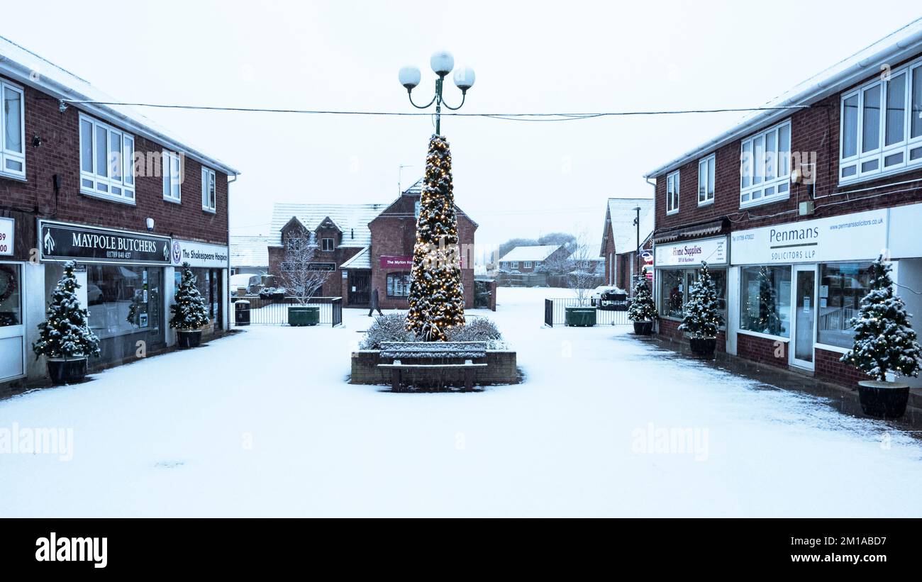 Einkaufsviertel Wellesbourne unter Schnee mit Weihnachtsbäumen und Lichtern. Stockfoto