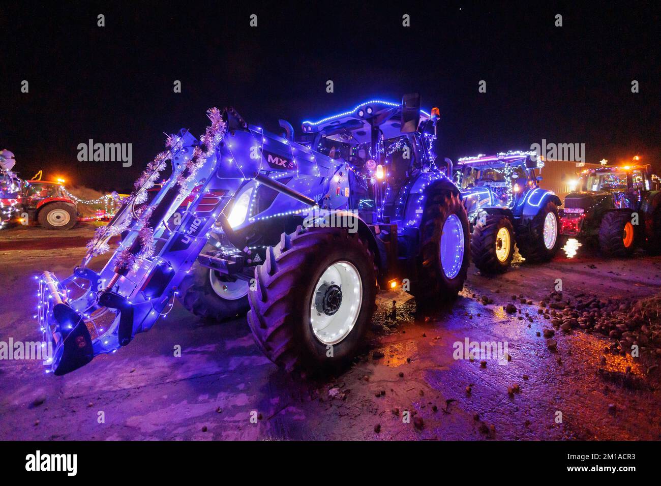 Der Weihnachtstraktor fährt durch North Warwickshire, England. Über 50 Traktoren sind mit bunten Lichtern dekoriert und fahren über zwei Nächte durch die Straßen und Spuren von North warwickshire. Die Veranstaltung, die von der Organisation Sheepy Ploughing organisiert wird, sammelt Geld für wohltätige Zwecke, während sie eine große Anzahl von Menschen erfreut, die das Spektakel bestaunen, das normalerweise ein paar Wochen vor Weihnachten stattfindet. Die Traktoren sind in Grendon, North Warwickshire, abgebildet, wo die A5 Boot Hill kreuzt. Stockfoto