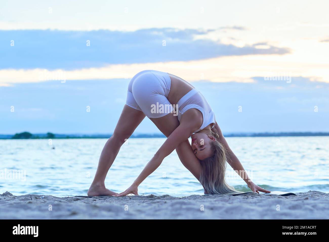 Junge Frau, die am Ufer des Sees trainiert. Stockfoto