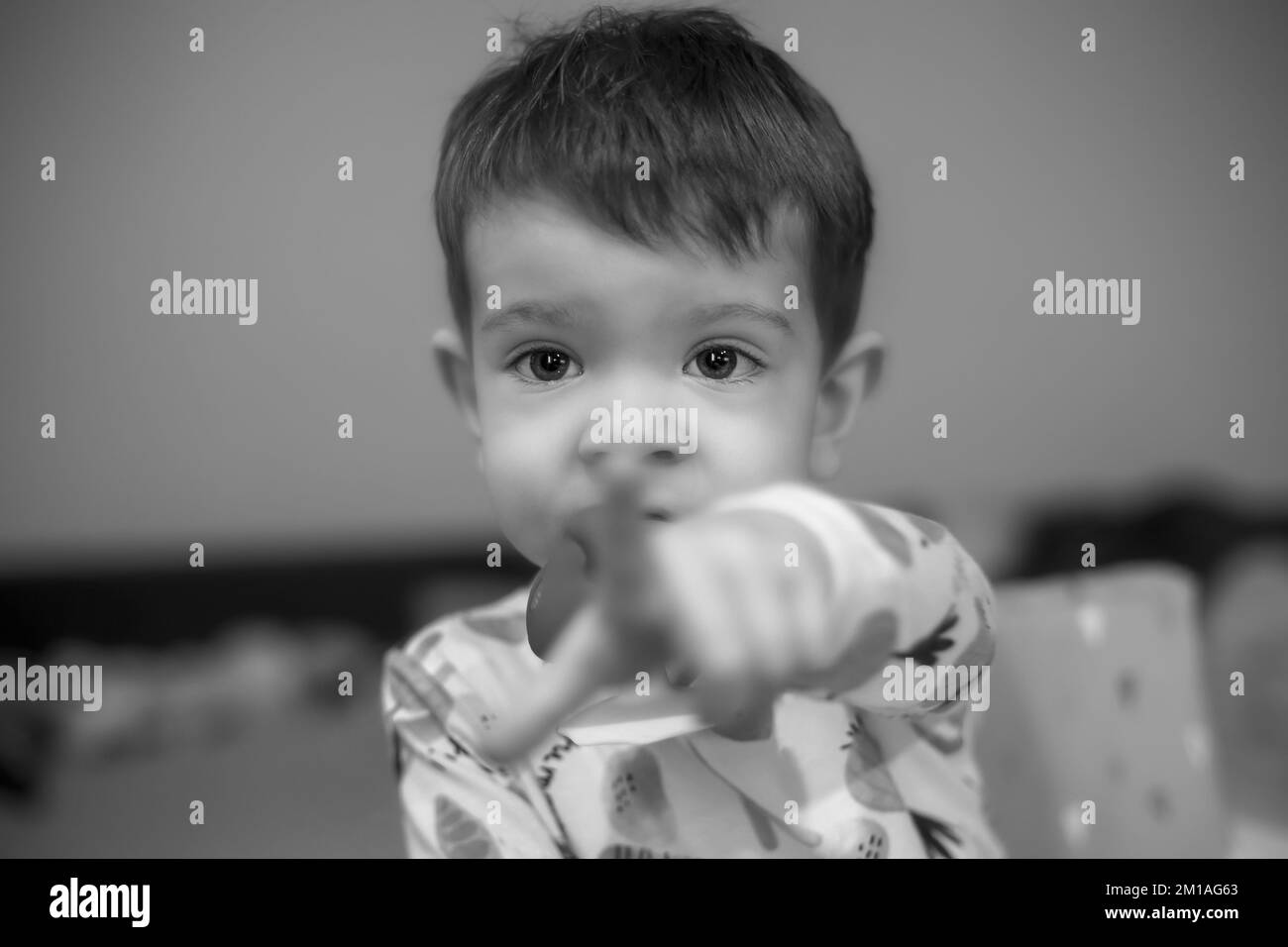 Schwarz-Weiß-Porträt eines Jungen, der mit dem Finger auf etwas vor ihm zeigt Stockfoto