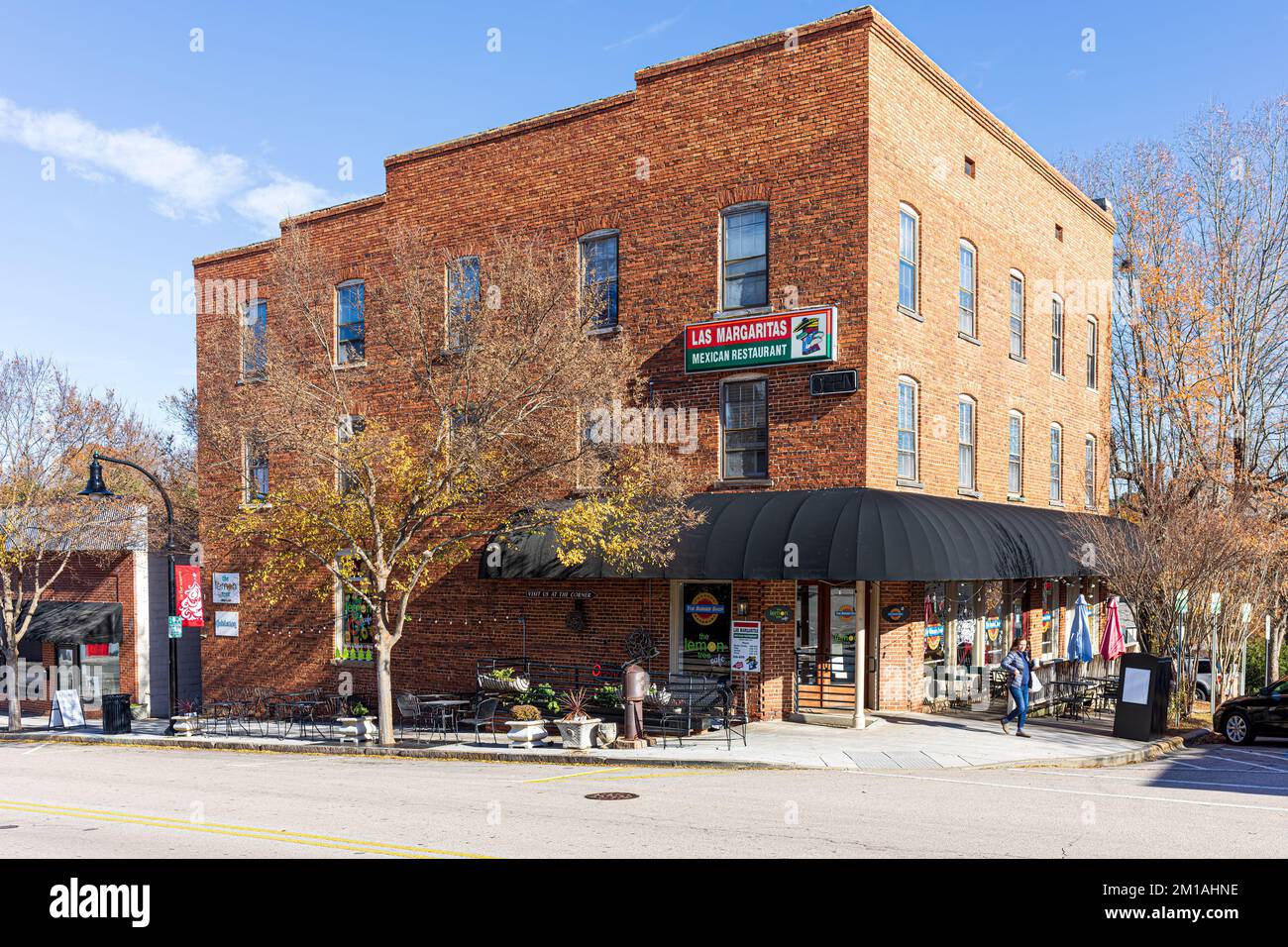 1. DEZEMBER 2022 - WAKE FOREST, NC, USA: Historisches Eckgebäude mit dem mexikanischen Restaurant Las Margaritas. Eine Frau verlässt das Gebäude. Stockfoto