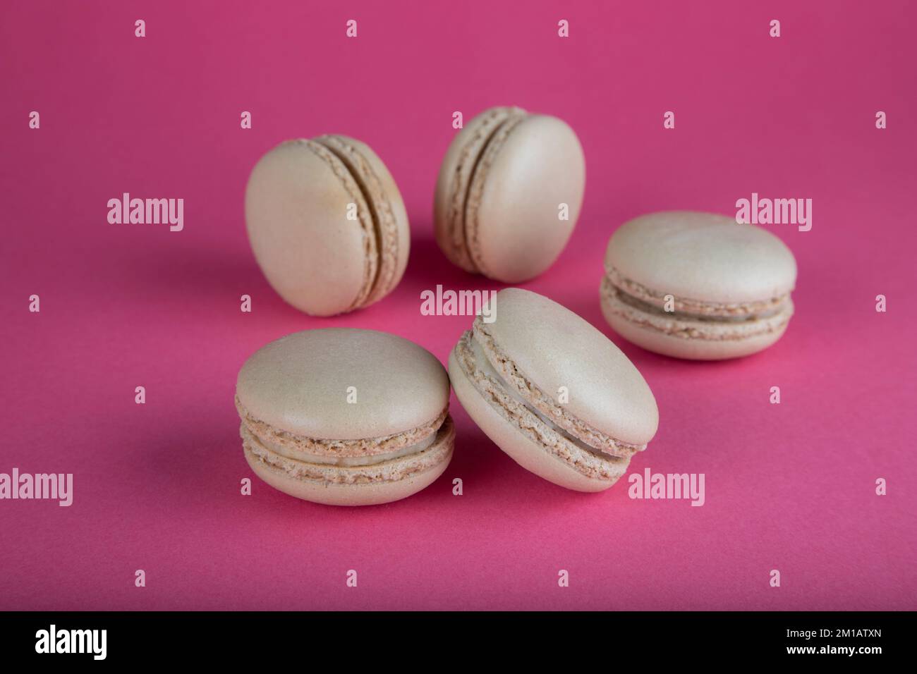 Nahaufnahme von beigen Makkaronkuchen auf rotem Hintergrund Stockfoto