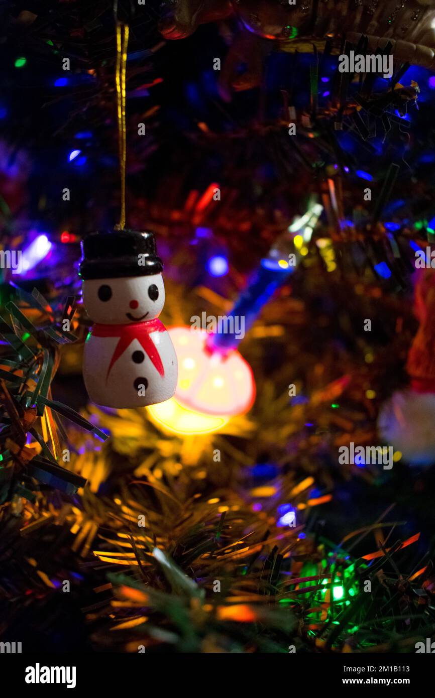 Antikes Schneemannsschmuck aus Holz mit klassischem Licht an einem Weihnachtsbaum Stockfoto