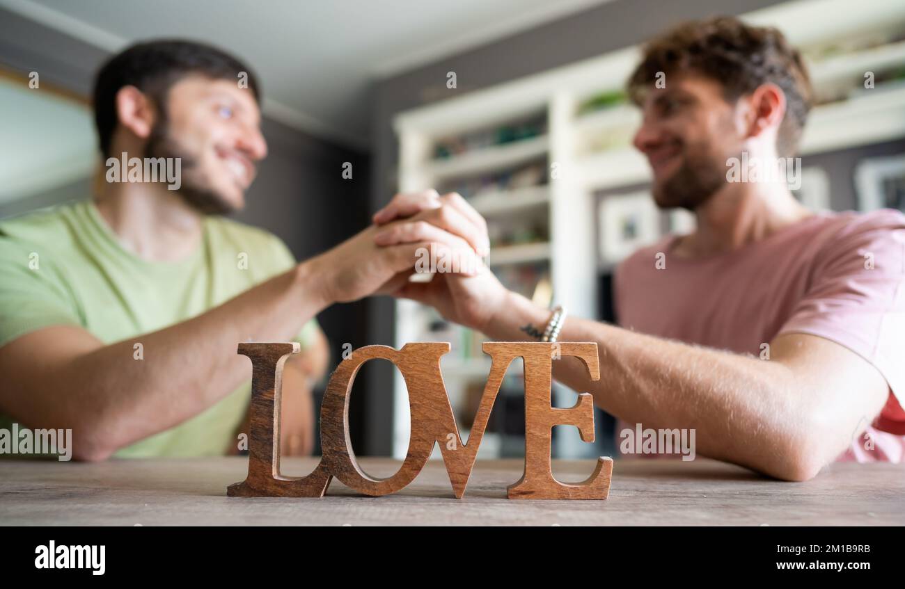 Zwei Männer schütteln sich die Hand mit der Vordergrundschrift Liebe Stockfoto