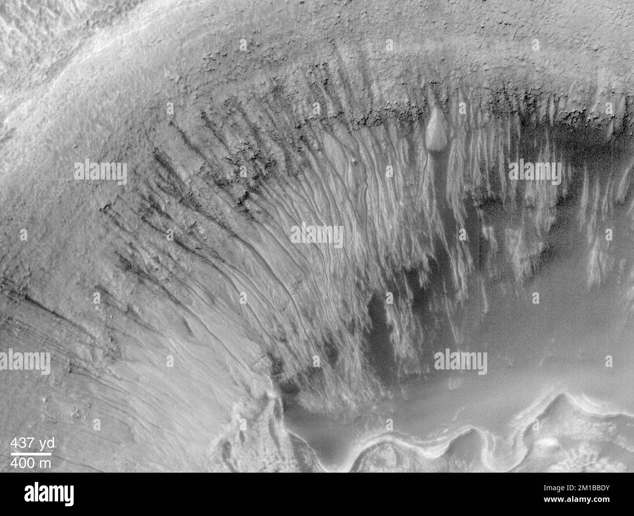 Newton Crater ist ein großes Becken, das durch einen Asteroidenaufprall entstanden ist, der wahrscheinlich vor mehr als 3 Milliarden Jahren stattfand. Es ist etwa 287 Kilometer (178 Meilen) breit. Das Bild hier (oben) zeigt die Nordwand eines bestimmten, kleineren Kraters im südwestlichen Viertel von Newton Crater (oben). Der Krater von Interesse wurde auch durch einen Aufprall geformt; er ist etwa 7 km (4,4 Meilen) breit, was etwa 7 Mal größer ist als der berühmte Meteorkrater im Norden Arizonas in Nordamerika. An der Nordwand des kleinen Kraters sind viele enge Schluchten eingebrochen. Stockfoto