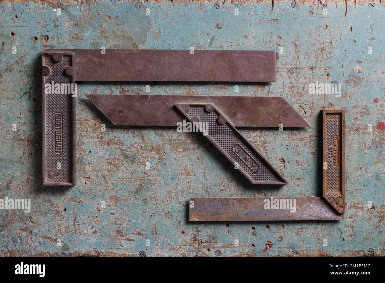 Alte, holzbearbeitende quadratische Werkzeuge liegen flach auf einem rustikalen Surafce oben Stockfoto
