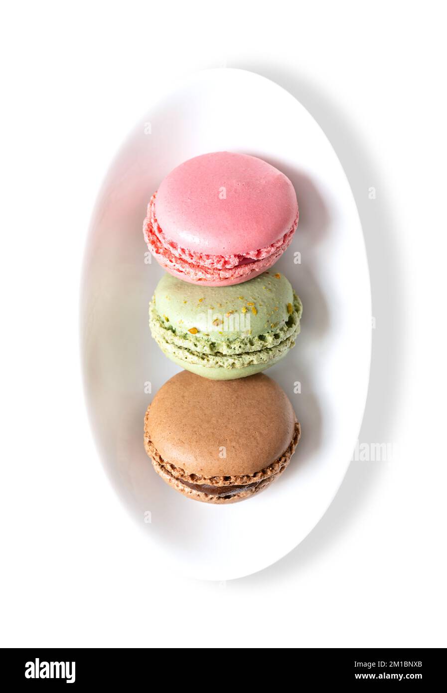 Makronen, französische Makronen in einer weißen Schüssel. Süße Konfekt auf Baiser-Basis im Pariser Stil, mit Eiweiß, Zucker, Mandeln und Lebensmittelfarben. Stockfoto