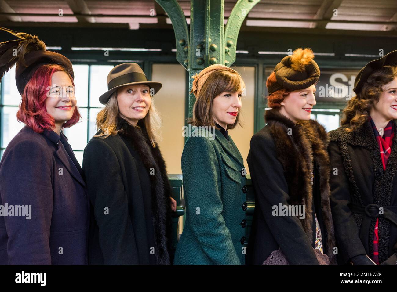 New York City, New York - 11. Dezember 2022: Menschen in antiken Kleidern warten auf den Zug der vielen Farben, Holiday Nostalgia Fahrten, NYC U-Bahn Stockfoto