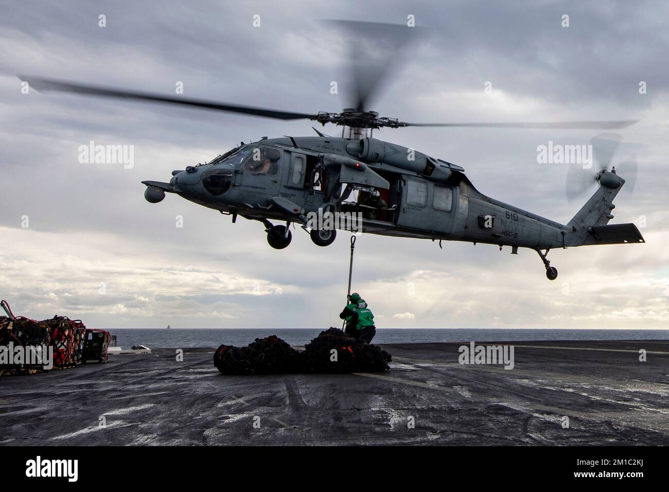 221211-N-MZ309-1115 ADRIATISCHE SEE (11. Dezember 2022) Seeleute, die dem Flugzeugträger USS George H.W. der Nimitz-Klasse zugewiesen sind Bush (CVN 77) bringt einen Frachthaken an einem MH-60s Nighthawk Helikopter an, der an Helicopter Sea Combat Squadron (HSC) 5 während einer Nachfüllung auf See mit dem Versorgungsschiff USNS Arctic (T-AOE 8), 11. Dezember 2022, befestigt ist. Carrier Air Wing (CVW) 7 ist die offensive Luft- und Streikkomponente der Carrier Strike Group (CSG) 10, George H.W. Buchse CSG. Die Geschwader von CVW-7 sind Strike Fighter Squadron (VFA) 86, VFA-103, VFA-136, VFA-143, Electronic Attack Squadron (VAQ) 1 Stockfoto