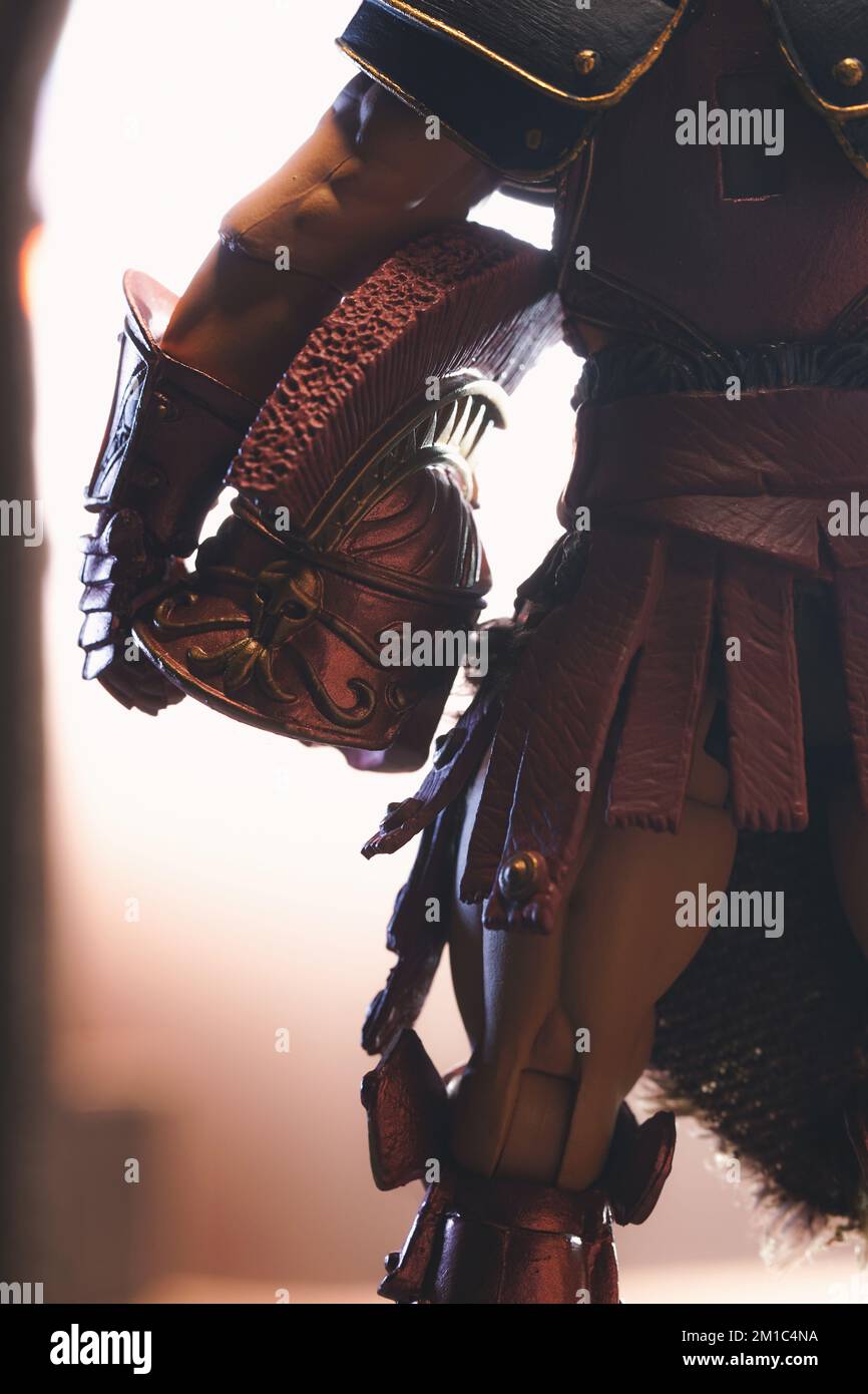 Eine epische Actionfigur einer Gladiatorenfigur, die seinen Helm an der Hüfte hält und eine wunderschöne Beleuchtung bietet Stockfoto