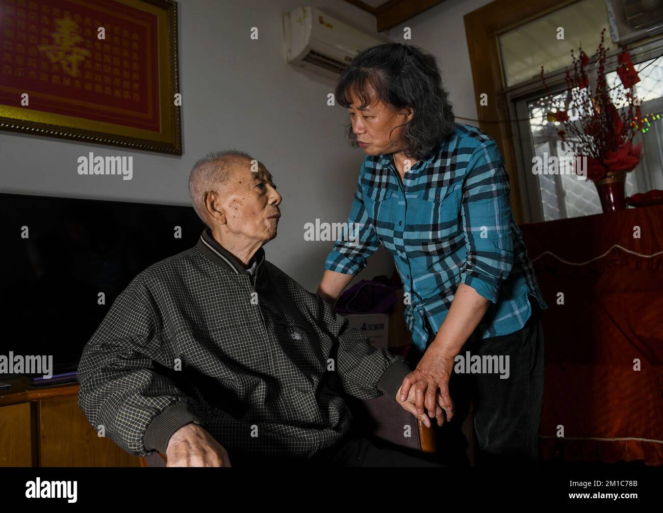 (221212) -- NANJING, 12. Dezember 2022 (Xinhua) -- Zhang Shixiang (L), ein Überlebender des Nanjing-Massakers, unterhält sich mit seiner Tochter zu Hause in Nanjing, Ostchina Provinz Jiangsu, 27. April 2022. In diesem Jahr jährt sich das Massaker von Nanjing zum 85.. Mal. Das Massaker von Nanjing fand statt, als japanische Truppen am 13. Dezember 1937 die damalige chinesische Hauptstadt eroberten. In sechs Wochen töteten sie in einer der barbarischsten Episoden des Zweiten Weltkriegs etwa 300.000 chinesische Zivilisten und unbewaffnete Soldaten.bis zum 11. Dezember 2022 ist die Zahl der registrierten Überlebenden des Massakers auf 54 zurückgegangen. Bericht Stockfoto