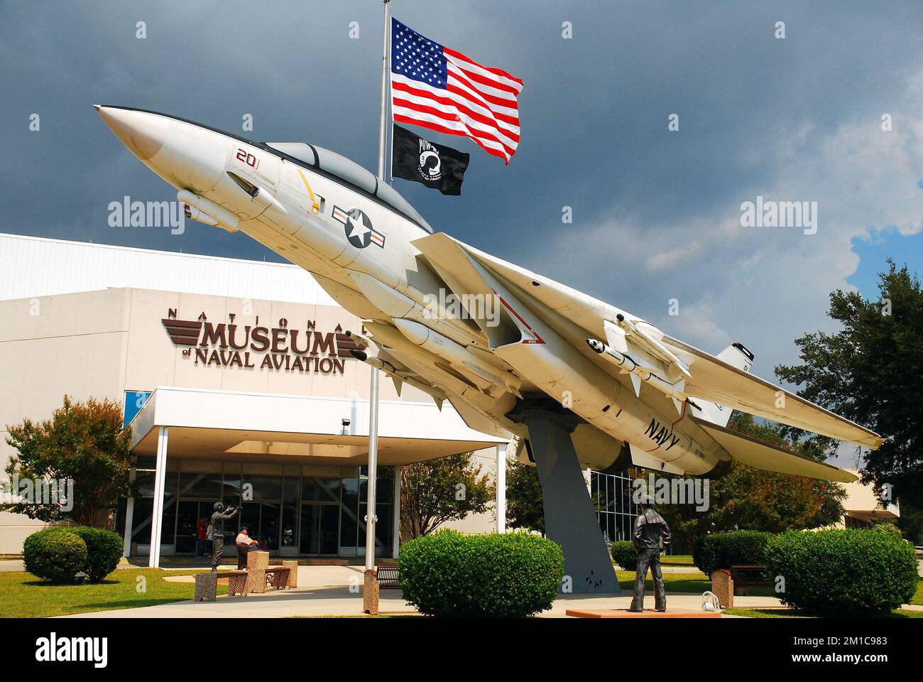 Vor dem Museum of Naval Aviation in Pensacola wird ein Grumman F14 ausgestellt, hinter dem eine amerikanische Flagge im Wind weht Stockfoto