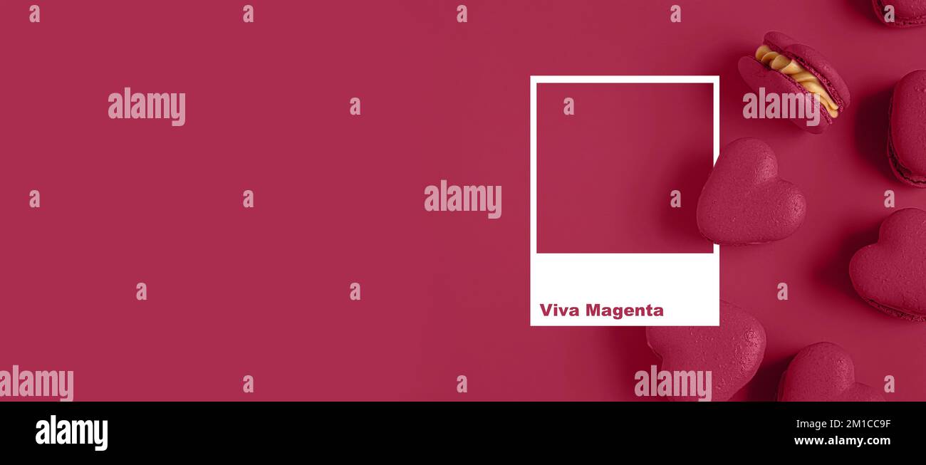 Leckere herzförmige Makronen auf farbigem Hintergrund mit Platz für Text. Viva Magenta - Farbe des neuen Jahres 2023 Stockfoto