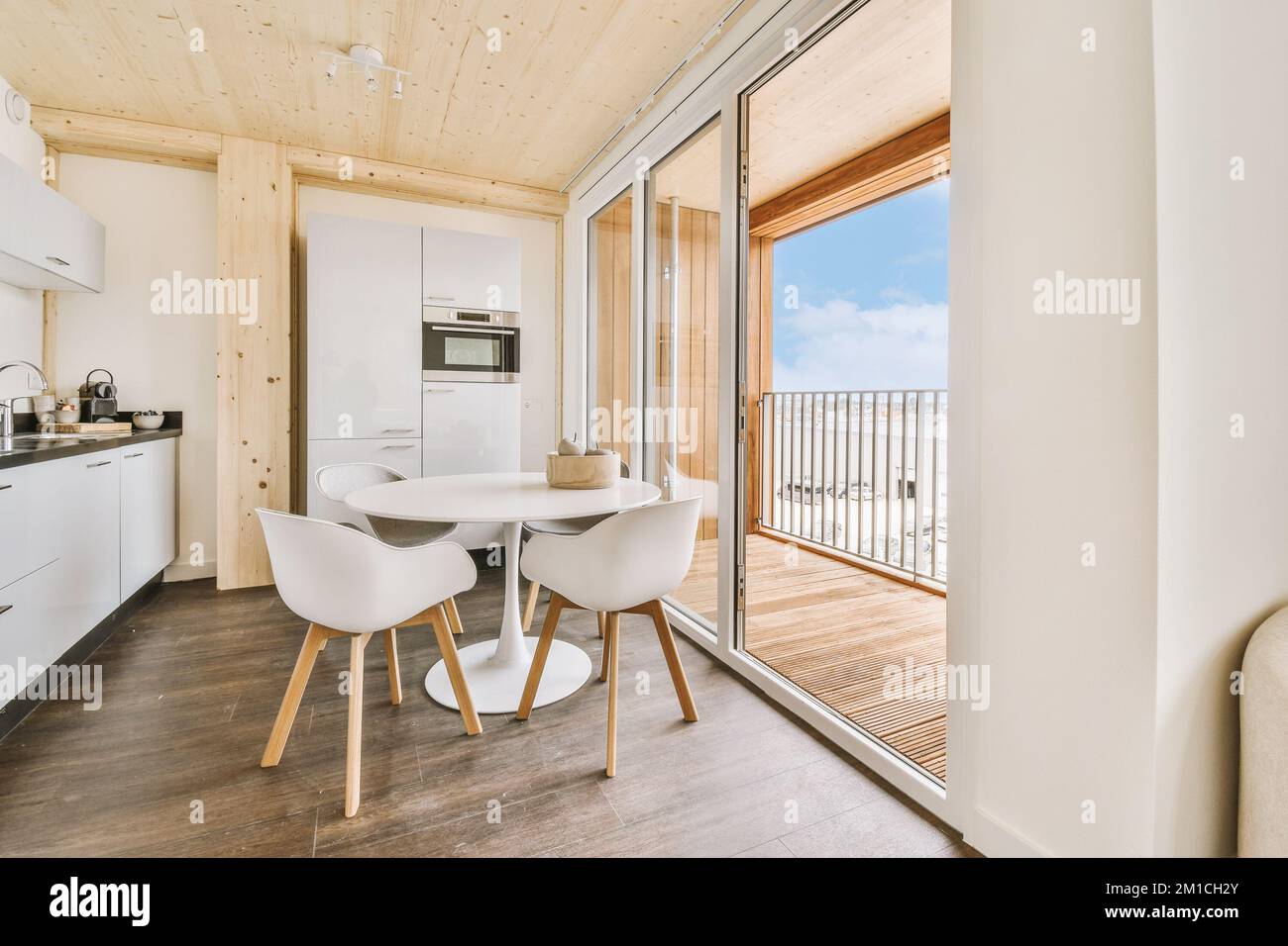 Home Interior Design der modernen Loft-Wohnung mit offener Küche In minimalistischem Stil und geräumiger Essecke mit Tisch und Stühle Stockfoto