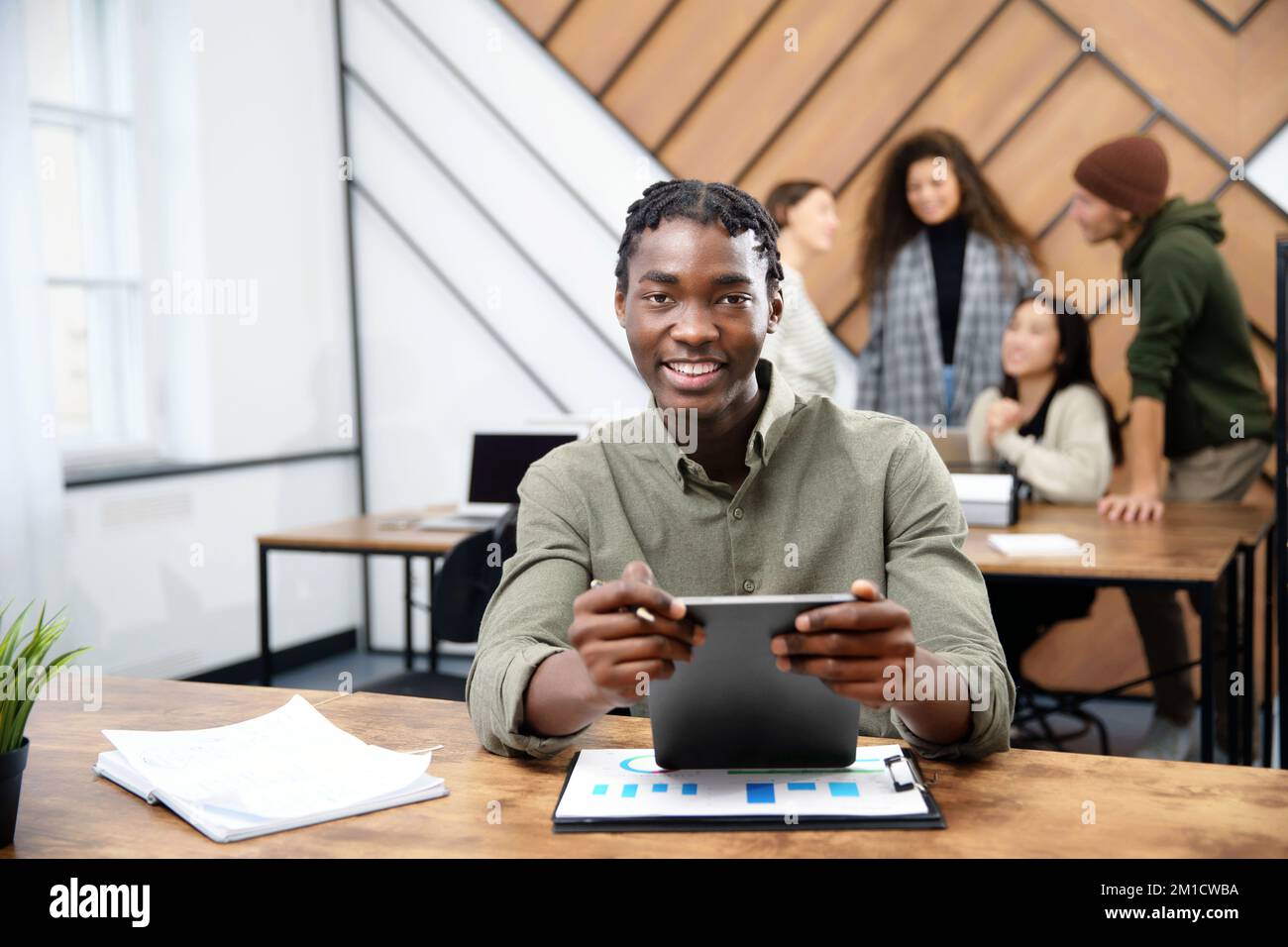 Ein junger Mann mit einem digitalen Tablet arbeitet in einem Co-working-Center. Stockfoto