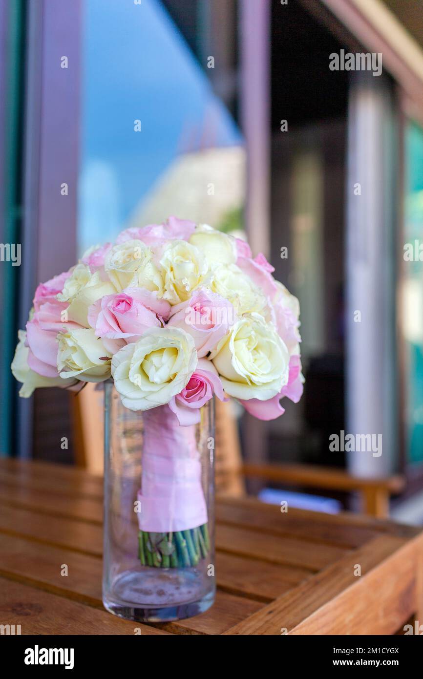 Ein Strauß Rosen, in einer Vase, auf dem Tisch, frisch und schön, mit rosa und gelben Blumen Stockfoto