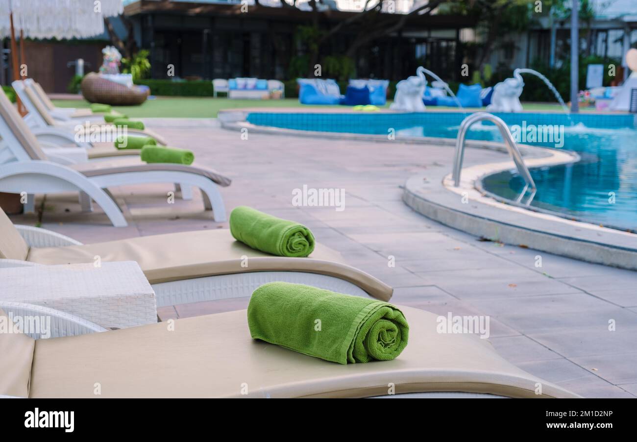 Liegestühle am Swimmingpool mit Sonnenschirmen, Liegestühle am Pool Stockfoto
