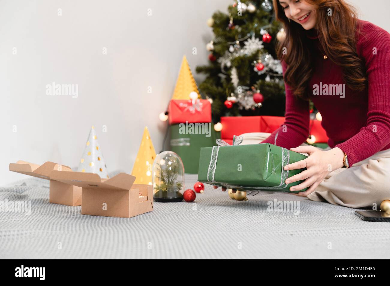 Glückliche Frau, die ihr Geschenk zu Weihnachten zu Hause hält. Heirate Weihnachten und frohe Feiertage Stockfoto
