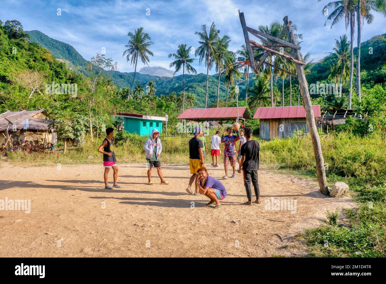 Ländliche Occidental Mindoro Province, Philippinen - 19. Februar 2022. Eine Gruppe philippinischer Männer, die an einem Samstag auf einem Gemeindeplatz im Freien Basketball spielen. Stockfoto