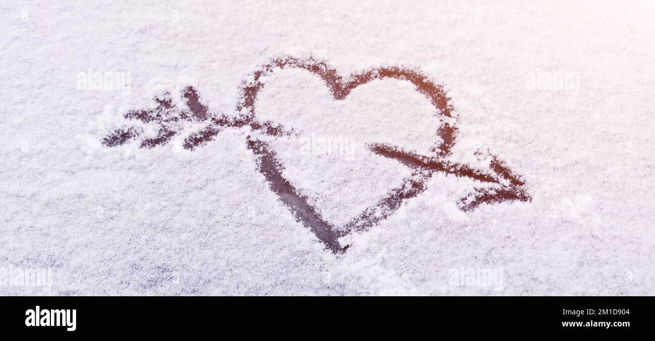 Herz im Schnee mit Pfeil ist ein Symbol für ewige Liebe und Feier - Valentinstag Stockfoto