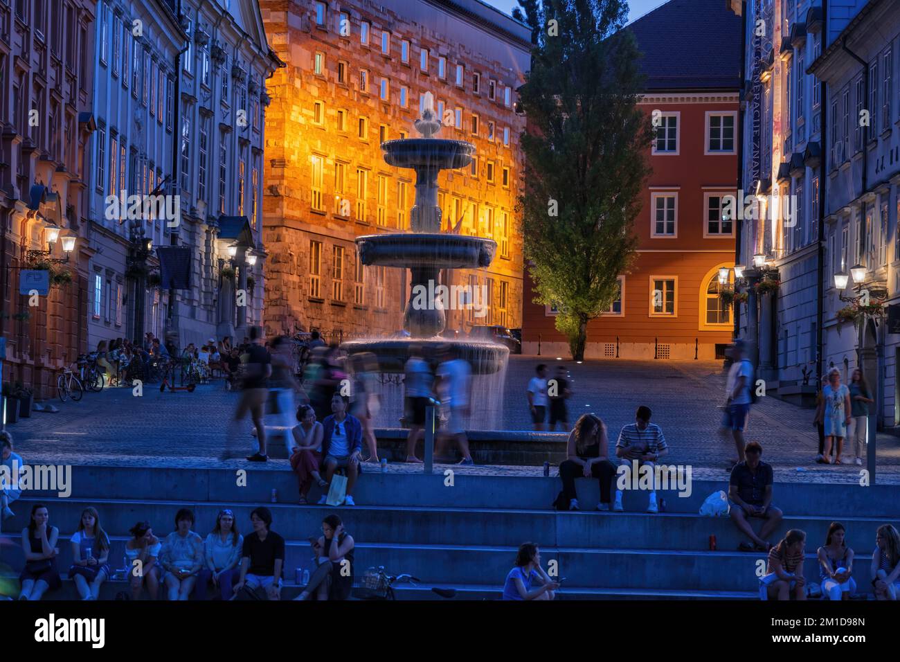 Abend in der Stadt Ljubljana in Slowenien, Menschen am Brunnen auf dem Neuen Platz (Novi Trg). Stockfoto