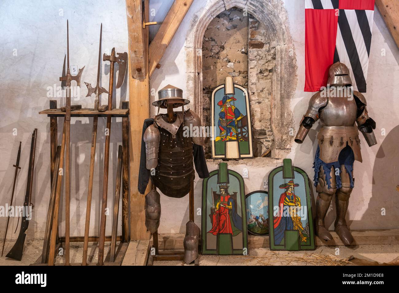 Schloss Predjama, Slowenien, mittelalterliche Waffenkammer mit Panzern, bemalten Schilden, Halberden, Waffen. Stockfoto