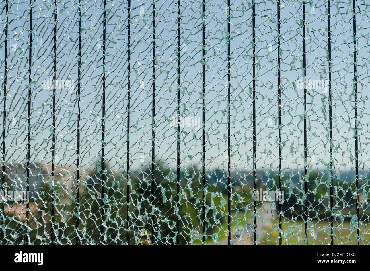 Zerbrochenes Glas einer Sicherheitsgitter entlang einer Straße, die eine Brücke überquert Stockfoto